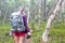 Woman in wilderness hikes with binoculars