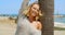 Woman with Wind Swept Hair Next to Tree on Beach