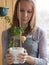 Woman at the window with a plant pomegranate. Caring for houseplants in the winter.