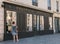 Woman window shops outside fashion store in historic pharmacy