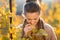 Woman winegrower inspecting grape vines in autumn vineyard