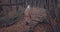 Woman in winter clothes walking hills in the rainy wood