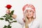 Woman in winter furry hat holding red rose