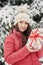 Woman in winter park with gift box. .Beautiful girl in winter snowy forest.  Christmas, holidays and leisure concept - happy young