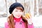 Woman in winter in a park with orange in hands