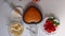 A woman wipes the form with baked biscuit. Next to the saucer is a strawberry.