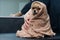 A woman wipes a Pomeranian with a beige towel after washing. Spitz dog in the grooming salon.