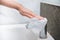 Woman wiping faucet with antibacterial disinfecting wipe for killing corona virus on touching bathroom handle with tissue.