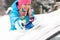 Woman wiping snow car window using brush