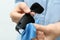 Woman wiping sunglasses with microfiber cleaning cloth on light background