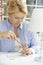 Woman Wiring Electrical Plug On Lamp At Home