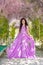 Woman wisteria lilac dress. Thoughtful happy mature woman in pur