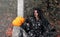 A woman in a witch hat with a creepy pumpkin head Jack lantern and a misty forest for Halloween