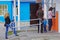 Woman withdrawing money from an ATM, other women waiting in line behind her in Berezovka