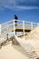 Woman in wooden staircase wood path with fence through dunes to the beach lacanau sea Atlantic coast