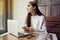 Woman work in cafe with laptop near window with coffee latte