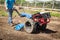 Woman worker driving rototiller tractor unit preparing soil