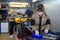 Woman worker repairing tractors engine with wrench