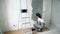 Woman worker using a spatula applying decorative plaster in the apartment or house. Construction, repair and renovation