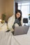 woman working in bed on laptop covered with blanket