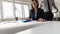 Woman working on a blue manual calculator in an office as her pa