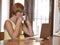 Woman working busy at coffee shop with laptop computer talking on mobile phone