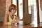 Woman working busy at coffee shop with laptop computer using mobile phone