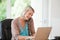 Woman working on her computer while she is phoning