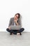 Woman working on her laptop, talking on phone sitting on floor