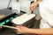 Woman working at ice cream factory is decorations of creamy vanilla and white chocolate ice cream.