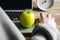 A woman working on laptop, apple closeup, snack concept.