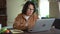 Woman working with laptop and sitting at desk in home office during pandemic.