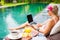 Woman working on laptop while sitting by the pool