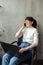 Woman working on a laptop and talking on a mobile phone at her workplace