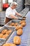 Woman working in a large bakery - industrial production of bakery products on an assembly line