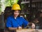 Woman working in mechanic uniform using measuring tools to cut wood sheets in factory