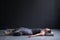 Woman working out, doing yoga exercise on wooden floor, lying in Shavasana