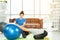 Woman working out with fitness ball of sportswomen practicing yoga. Stretching using fitness ball at home