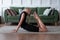 Woman working out at home, arching her back and reaching her toes for her head.