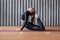 Woman working out at home, arching her back and reaching her toes for her head