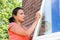 Woman working sanding window outdoors