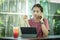 Woman working serious with a tablet computer at a wooden table. Next on the table is aIce with sweet water pink lemonade. concept