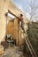 Woman working and standing on a ladder with a driller