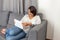 Woman working with tablet sitting on sofa