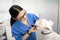 Woman working in veterinary clinics grooming white dog