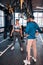 Woman working on weight loss lifting barbell standing near trainer