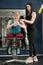 Woman workout in gym with her coach doing back exercises