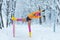 Woman workout outdoor in snow in colorful fitness clothes and wool cap park winter day