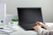 Woman works on laptop in online education on workspace. Female hands typing on laptop. Black laptop display Mock up blank.