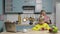 Woman works on laptop, talking on the phone and preparing cereal with milk for the boy. Mom and son in the kitchen